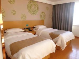 A bed or beds in a room at GreenTree Inn Wulanchabu High Speed Railway Station Huaiyuan South Road Express Hotel