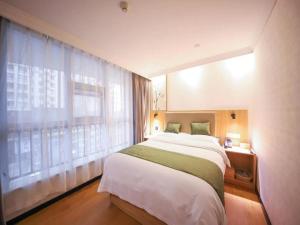 a bedroom with a large bed and a window at GreenTree Inn Anhui Hefei West Wangjiang Road Qianshan Road Express Hotel in Hefei