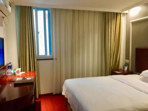 pokój hotelowy z łóżkiem i oknem w obiekcie GreenTree Inn Anhui Hefei Xierhuan Botanical garden Business Hotel w mieście Hefei