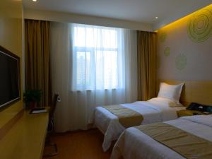 a hotel room with two beds and a window at GreenTree Inn Shijiazhuang Yuanshi County Beihuan Road in Shijiazhuang