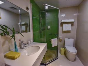 een badkamer met een wastafel, een douche en een toilet bij GreenTree Inn Huanggang Qichun County Ouyada Square Express Hotel in Qichun