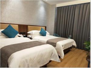 Un pat sau paturi într-o cameră la GreenTree Inn Yinchuan International Trade City Business Hotel