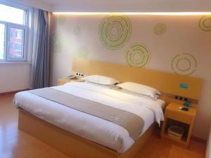 um quarto com uma grande cama branca e 2 almofadas em GreenTree Inn Wulanchabu High Speed Railway Station Huaiyuan South Road Express Hotel em Pingdiquan