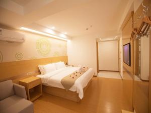 a bedroom with a large bed and a television at GreenTree Inn Haikou Chengmai Old Town Software Park Business Hotel in Bailian +28 photos
