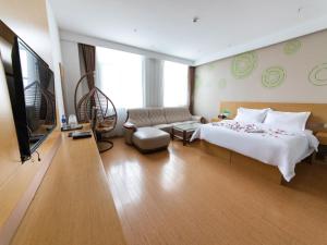 ZhuozhouにあるGreenTree Inn Baoding City Cangzhou Guanyun West Road Business Hotelのベッドとテレビが備わるホテルルームです。