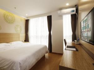 Un dormitorio con una gran cama blanca y una ventana en GreenTree Inn Chengde Development Zone University City Express Hotel, en Chengde