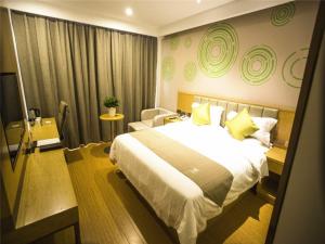 Habitación de hotel con cama grande y sofá en GreenTree Inn Xingtai Julu County Fengqing Road Business Hotel, en Xingtai