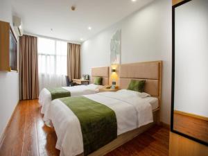 Rúm í herbergi á GreenTree Inn Changzhou Xinbei District Taihu Road Wanda Plaza Dinosaur Park Express Hotel