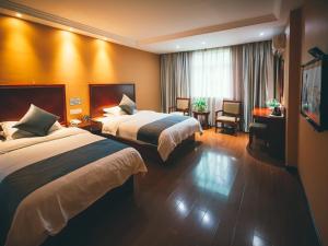 a hotel room with two beds and a television at GreenTree Inn Zhejiang Lishui Suichang Longgu Road Express Hotel in Suichang