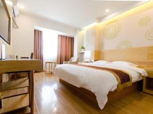 GreenTree Inn Jiangsu Suzhou North Zhongshan Road Weiye Yingchun Plaza Business Hotel tesisinde bir odada yatak veya yataklar