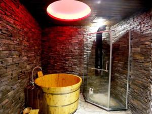 bagno con vasca in legno e parete di mattoni rossi di GreenTree Alliance Jinhua Dongyang East Bus Station Dongyong Road Hotel a Dongyang