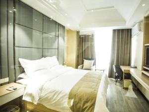 1 dormitorio con 1 cama blanca grande y escritorio en Shell Xuzhou Suining County Bali Electrical and Mechanical City Hotel en Sui-ning-hsien