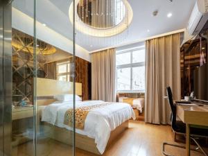 sypialnia z łóżkiem ze szklaną ścianą w obiekcie GreenTree Inn Changzhou Menghe Town Chengfeng Building Business Hotel w mieście Changzhou