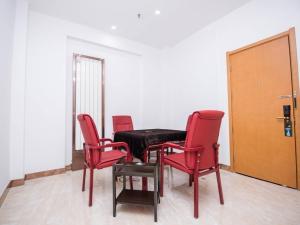 um quarto com cadeiras vermelhas, uma mesa e uma porta em GreenTree Inn Xuchang Yucheng County Ziyun Avenue Business Hotel em Xuchang