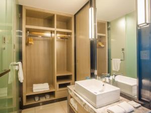 a bathroom with a sink and a shower and a mirror at GreenTree EasternLianyungang Wanda Plaza Hotel in Lianyungang +8 photos
