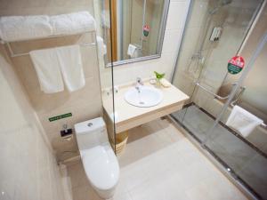 a bathroom with a toilet and a sink and a shower at GreenTree Alliance ZheJiang Huzhou Changxing Zhebei Business Square Hotel in Chenjiaqiao