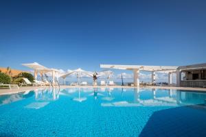 a swimming pool with a person standing in the middle at Akrogiali Beach Hotel Apartments in Malia