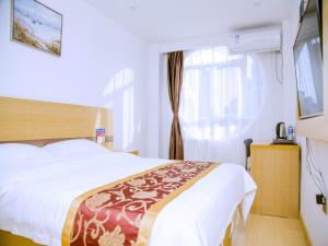 a bedroom with a large bed and a window at GreenTree Alliance Texas Railway Station Municipal Hospital Hotel in Dezhou