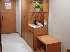 a small kitchen with a table and a potted plant at GreenTree Inn Xingtai Development Zone Zhongxing Road International New City Business Hotel in Xingtai +36 photos