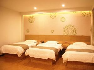 a group of four beds in a room at GreenTree Inn Shandong Jinan Gaoxin District South Gongye Road Middle Aoti Road Express Hotel in Jinan +37 photos