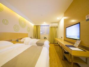 a hotel room with two beds and a flat screen tv at GreenTree Inn Beijing Tongzhou District Xuxinzhuang Subway Station Express Hotel in Beijing