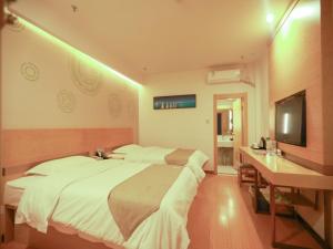 - une chambre avec un lit, un bureau et une télévision dans l'établissement GreenTree Inn Chengde Fengning Manchu Autonomous County Ningfeng Road Express Hotel, à Fengning