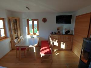 ein Esszimmer mit einem Tisch, Stühlen und einem TV in der Unterkunft kleine Reblaus in Bad Waltersdorf