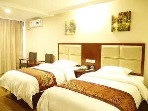 a hotel room with three beds in a room at Greentree Tangshan Nanhu Jindi Business Hotel in Tangshan