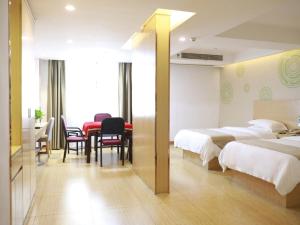 ein Hotelzimmer mit 2 Betten, einem Tisch und Stühlen in der Unterkunft GreenTree Inn Xianning Tongcheng Bus Station Business Hotel in Tongcheng