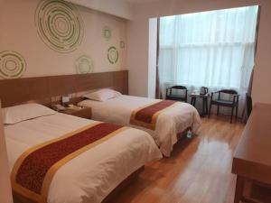 una camera d'albergo con due letti e una finestra di GreenTree Inn Shanxi Changzhi Lucheng Zhonghua Street Business Hotel a Lucheng