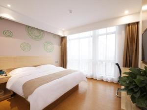 um quarto com uma cama grande e uma janela grande em GreenTree Inn Hefei Lujiang County Yihu West Road Chengxi No.4 Middle School Express Hotel em Lujiang