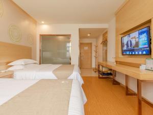 um quarto de hotel com duas camas e uma televisão de ecrã plano em GreenTree Inn LiuAn Huoshan County Yingjia Avenue County Hospital Express Hotel em Huoshan