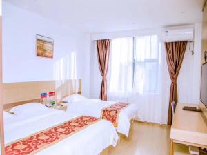 a hotel room with two beds and a window at GreenTree Alliance Texas Railway Station Municipal Hospital Hotel in Dezhou