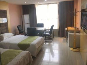 um quarto de hotel com duas camas e uma mesa e cadeiras em GreenTree Alliance Ganzhou City Ningdu County Meijiang Town Sanhuan South Road Hotel em Ningdu