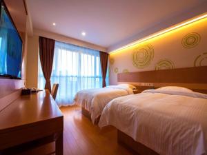 a hotel room with two beds and a flat screen tv at GreenTree Inn Xingtai Development Zone Zhongxing Road International New City Business Hotel in Xingtai