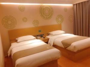 a hotel room with two beds and a window at GreenTree Inn Wulanchabu High Speed Railway Station Huaiyuan South Road Express Hotel in Pingdiquan