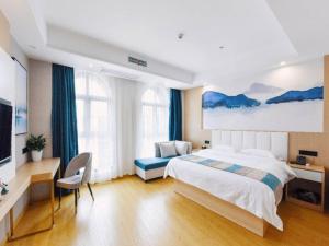 a bedroom with a bed and a desk and a tv at VX Wuxi Jiangyin High-tech Zone Panlongshan Park Hotel in Jiangyin