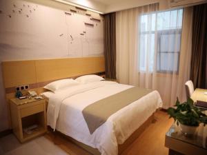 ein Schlafzimmer mit einem großen Bett und einem Fenster in der Unterkunft GreenTree Inn Hefei Economic Development Zone Qingtan Road One six eight Middle SchoolExpress Hotel in Hefei