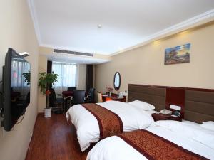 a hotel room with two beds and a television at GreenTree Inn JiangSu KunShan Lujia Town Furong Road Express Hotel in Kunshan