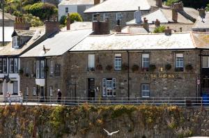 an old stone building with the star inn written on it at The Ship Inn in Mousehole