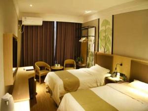 Habitación de hotel con 2 camas y escritorio en GreenTree Inn Puyang Hualong District Zhongyuan Road Hotel en Zhongyuanyoutian