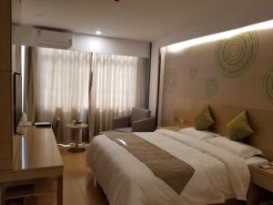a hotel room with a large bed and a chair at GreenTree Heze Changcheng Road Tianhua E-commerce Logistics Park Express Hotel in Heze