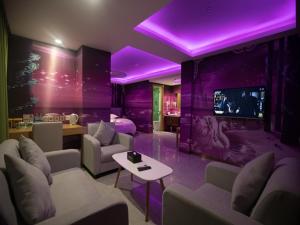 a living room with purple lighting and a tv at GreenTree Inn Haikou Chengmai Old Town Software Park Business Hotel in Bailian
