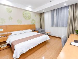 una camera d'albergo con un letto e una scrivania di GreenTree Inn Xuchang Yucheng County Ziyun Avenue Business Hotel a Xuchang