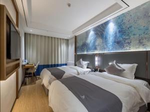 a hotel room with two beds and a tv at GYA Xuzhou High Speed Railway Station West Exit Station Hotel in Xuzhou