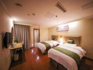 a hotel room with two beds and a television at GreenTree Inn Anhui Hefei West Wangjiang Road Qianshan Road Express Hotel in Hefei
