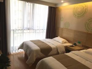 Säng eller sängar i ett rum på GreenTree Inn Chengde Development Zone University City Express Hotel