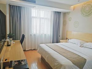 a bedroom with a bed and a desk and a window at GreenTree Inn LuAn Yeji District Yeji Railway Station Express Hotel in Sifangtang
