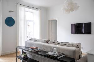 uma sala de estar com um sofá e uma mesa em MIRO Rooms French - quiet chic, free private parking em Riga