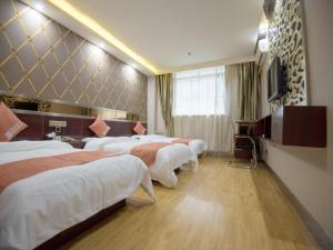 Habitación de hotel con 3 camas y TV en Shell Dingxi County Minzhou East Road Hotel en Min